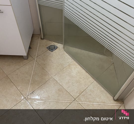 מקלחון עם דלת זכוכית ורצפת אריחים